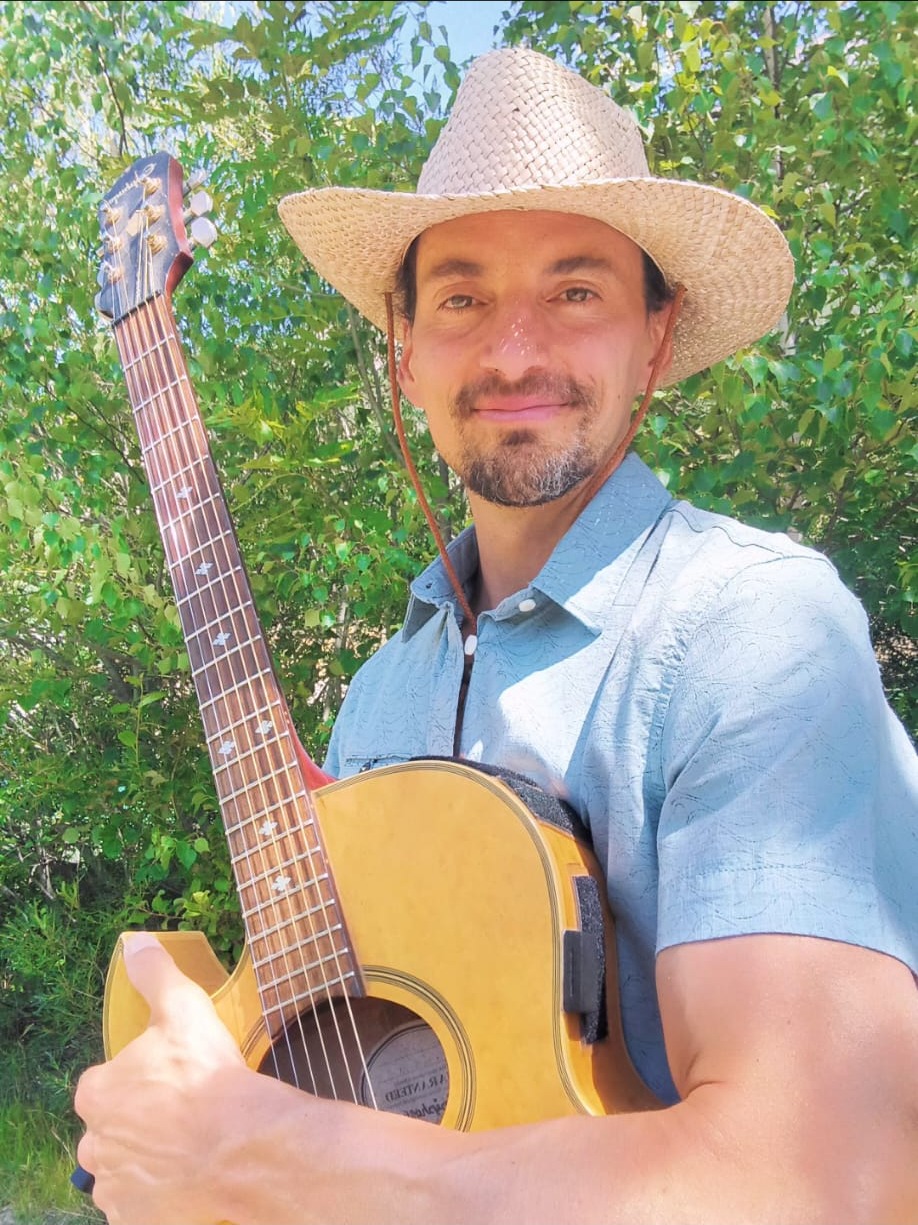 Pierre Ma avec son chapeau et sa guitare
